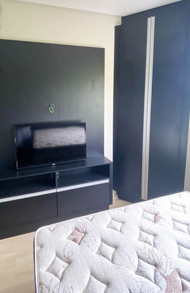 Dormitório com painel de televisão e roupeiro